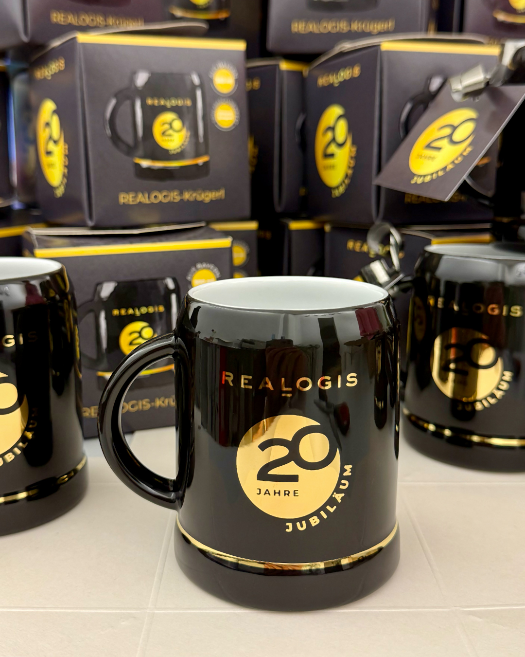 Schwarzes Realogis-Krügerl mit Logo in 24 Karat Gold