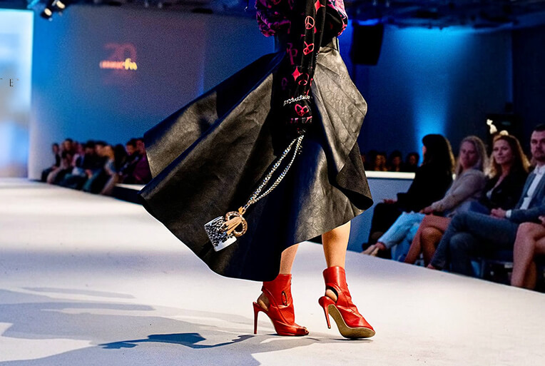 LOGOKRUG Krügerl als Fashion-Accessoire auf dem Laufsteg an der Kette getragen