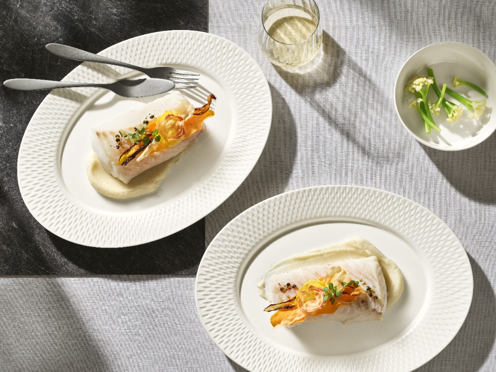 Weiße Platten mit Fisch, Glas und Schälchen